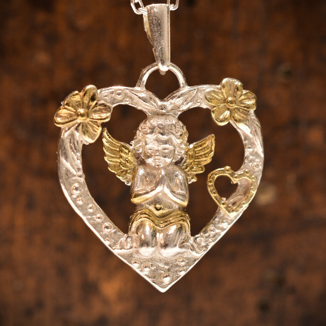 Сребърен медальон 925 във формата на сърце с ангел в молитва и позлатени акценти – бохо-рустик скулптурно ръчно изработено бижу от ArtDiva, символ на любов и закрила.