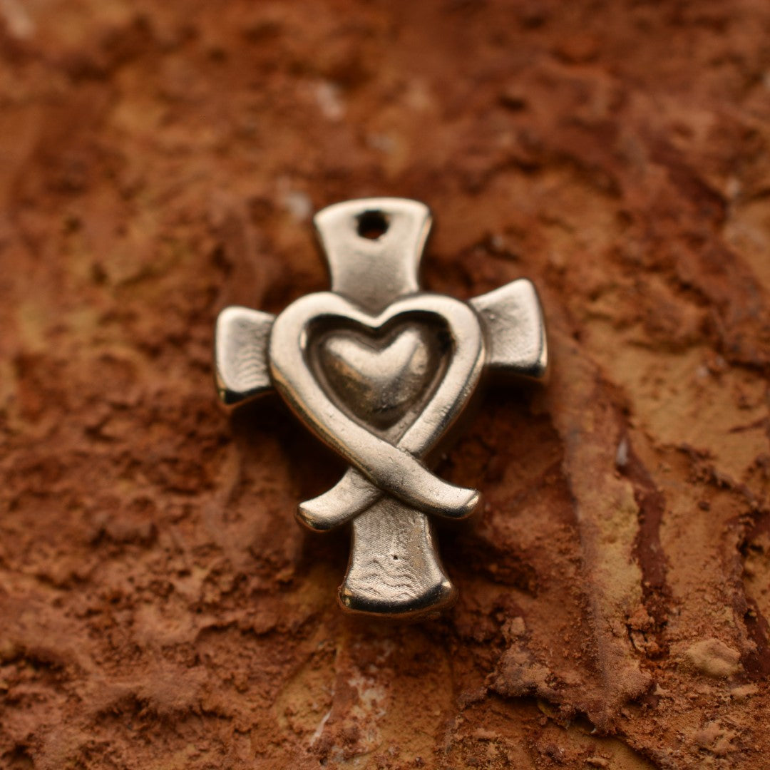 Сребърен медальон 925 „Кръст със сърце“ – ръчно изработен талисман на вярата и любовта, бохо-рустик скулптурно бижу от Арт Дива, заснето върху каменен фон.