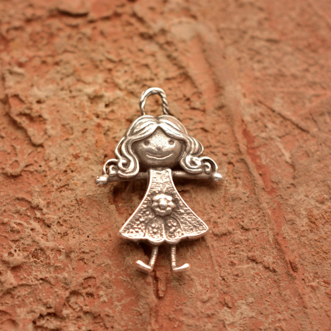 Сребърен медальон 925 „Прегръдка“ – ръчно изработен талисман във форма на усмихнато момиче, символ на обич и приятелство, бохо-рустик скулптурно бижу от Арт Дива, заснето върху каменен фон.