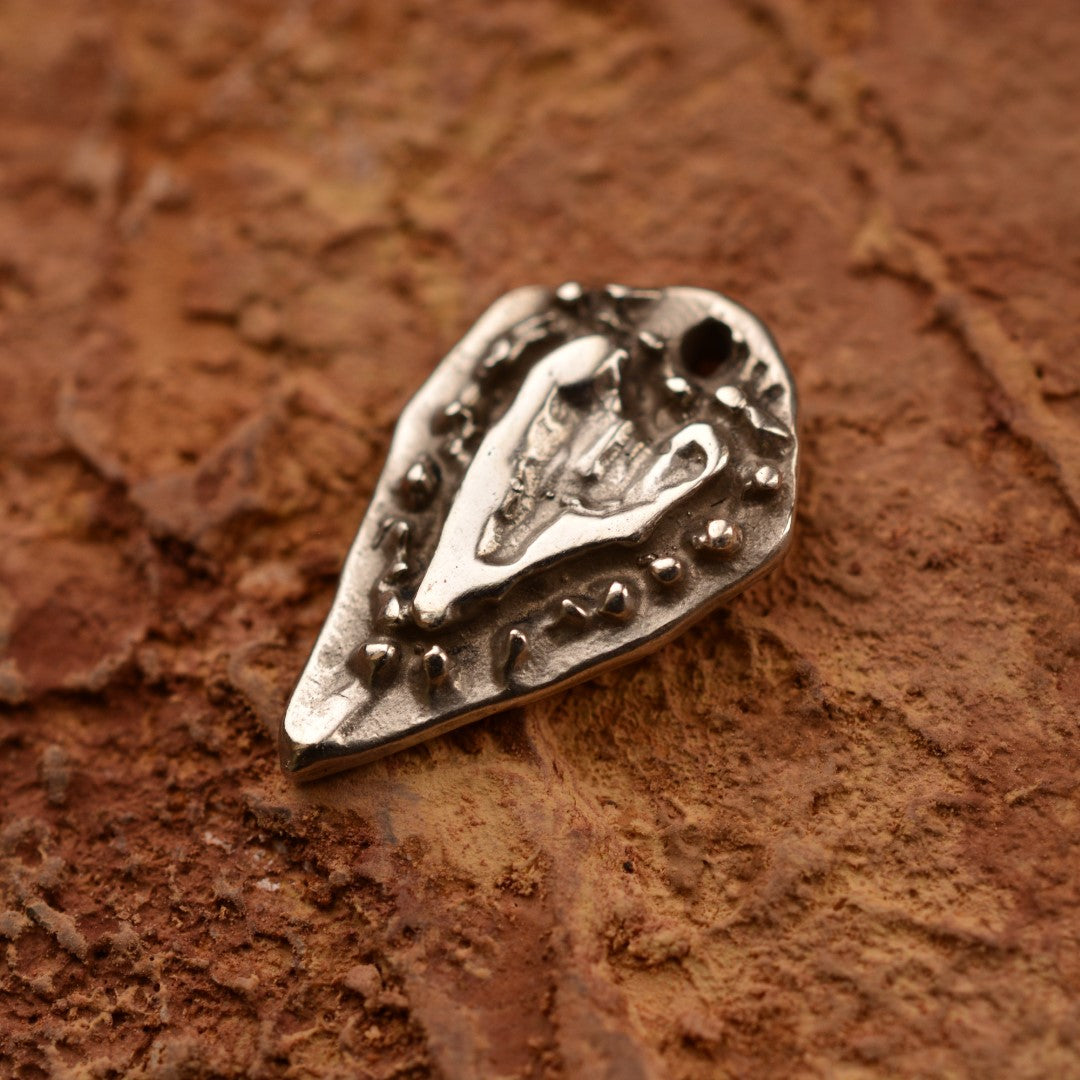 Сребърен медальон 925 „Сърце на обич“ – ръчно изработен талисман за любов и нежност, бохо-рустик скулптурно бижу от Арт Дива, заснето върху каменна текстура.