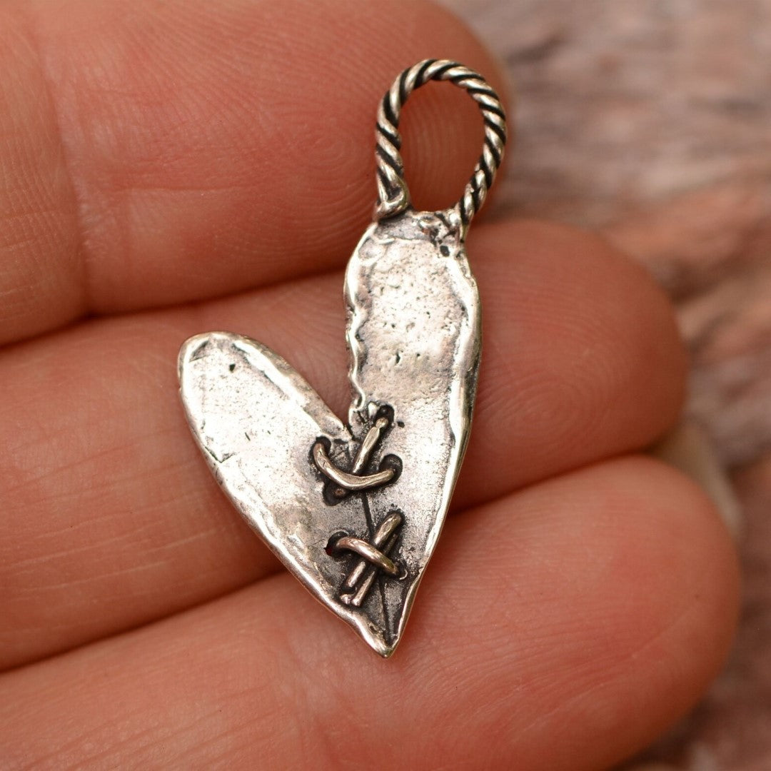 Сребърен медальон 925 „Закърпено сърце“ – ръчно изработено бохо-рустик скулптурно бижу от Арт Дива, талисман за любов, прошка и вътрешна сила, заснето върху ръка.