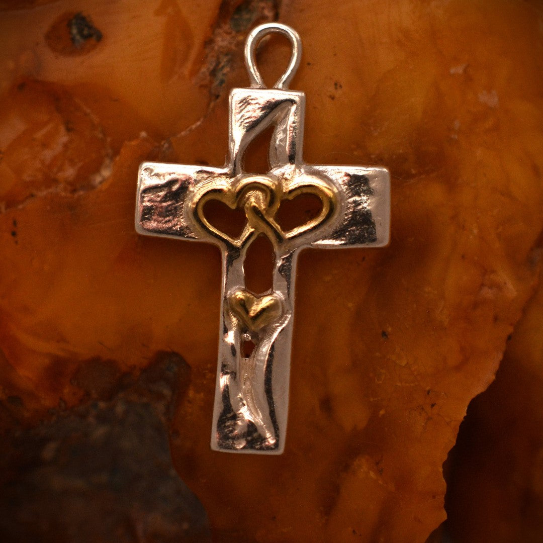 Сребърен медальон 925 кръст с три сърца и златни акценти, символ на любов, вяра и семейно единство, ръчно изработено бохо-рустик скулптурно бижу от Арт Дива.