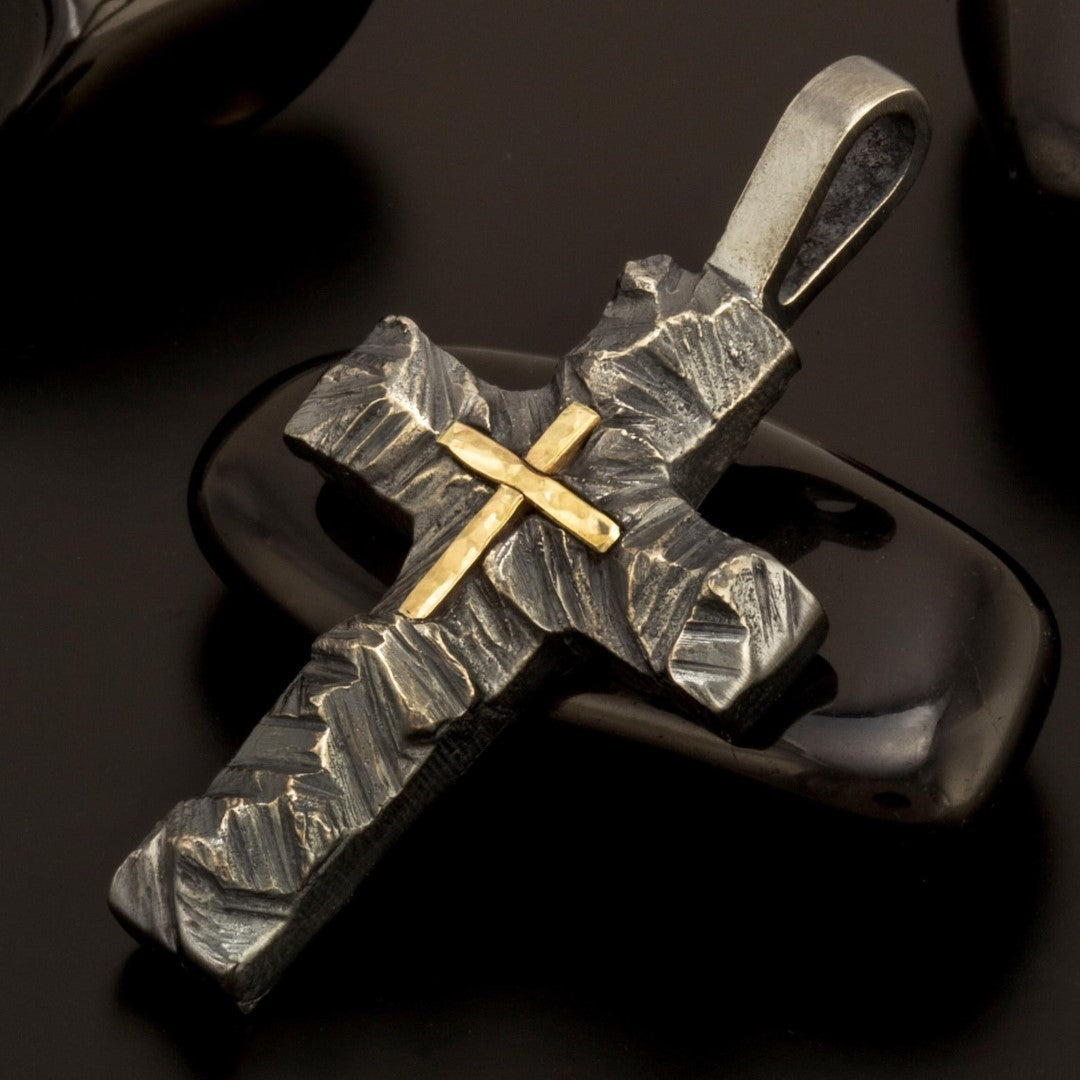 Сребърен кръст 925 с релефна текстура и златен акцент – символ на вяра, духовна сила и закрила, ръчно изработен бохо-рустик скулптурен медальон от Арт Дива, заснет на тъмен фон.

