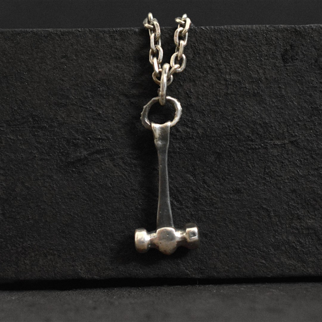 Мъжки медальон от сребро 925 „Чукът на Тор“ – ръчно изработен талисман на силата и закрилата, бохо-рустик скулптурно бижу от Арт Дива, заснето върху тъмен каменен фон.
