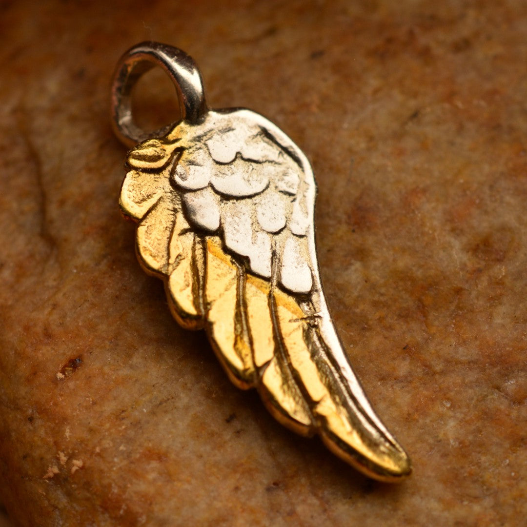 Сребърен медальон 925 „Ангелско крило“ със златни акценти – ръчно изработен амулет за закрила, сила и светлина, бохо-рустик скулптурно бижу от ArtDiva, заснето върху камък.