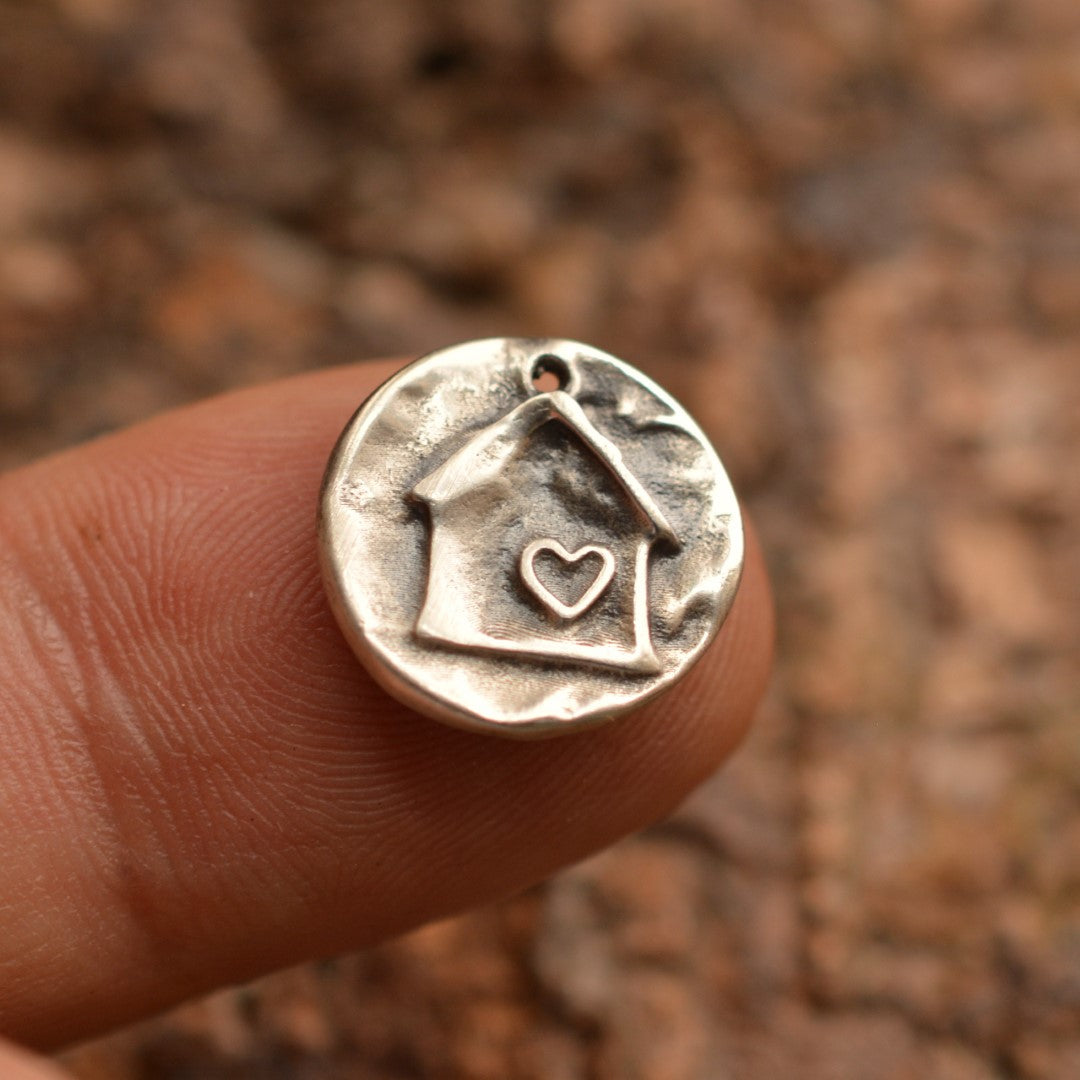 Сребърен медальон 925 „Домът е всичко“ – ръчно изработен талисман на семейния уют, обич и принадлежност, бохо-рустик скулптурно бижу от Арт Дива, заснето върху топъл естествен фон.

