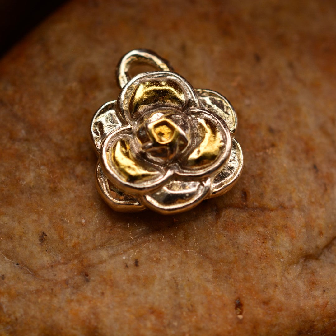 Сребърен медальон 925 „Камелия“ със златни акценти – ръчно изработен амулет на красота, женственост и сила, бохо-рустик скулптурно бижу от ArtDiva, заснето върху камък.