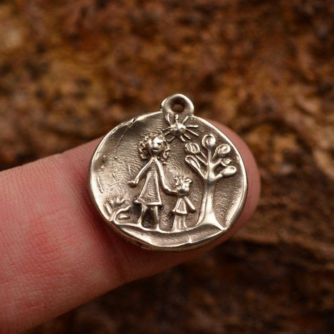 Сребърен медальон 925 „Майка и дете“ – ръчно изработен талисман на обичта и семейната връзка, бохо-рустик скулптурно бижу от Арт Дива, заснето върху естествен фон.
