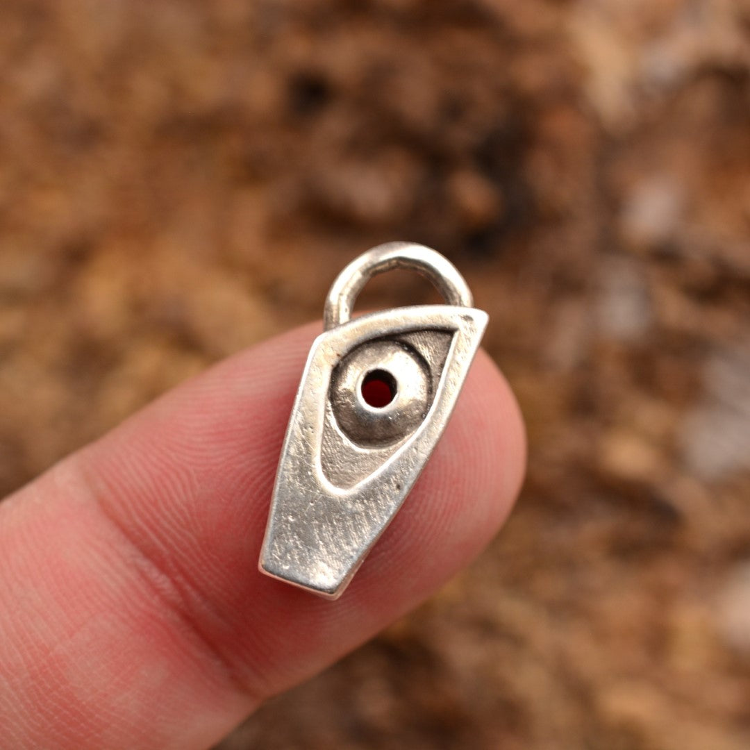 Сребърен медальон 925 „Око на закрилата“ – ръчно изработен талисман за защита и интуиция, бохо-рустик скулптурно бижу от ArtDiva, заснето върху кафяв камък.