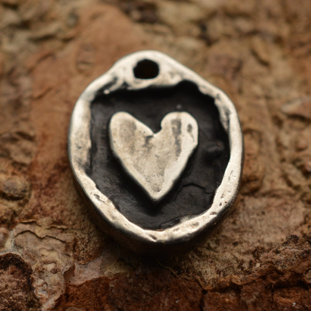 Сребърен медальон 925 „Рустикално сърце“ – ръчно изработен талисман и амулет на любовта и връзката, бохо-рустик скулптурно бижу от Арт Дива, заснето върху каменен фон.