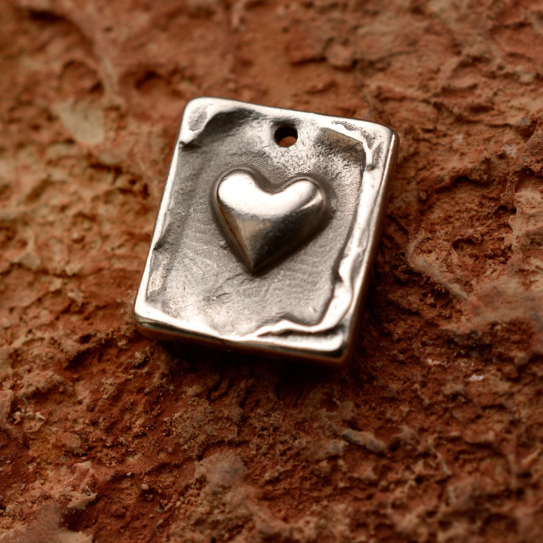 Сребърен медальон 925 „Сърце“ – ръчно изработен талисман за любов и закрила, бохо-рустик скулптурно бижу от Арт Дива, заснето върху естествен глинен фон.
