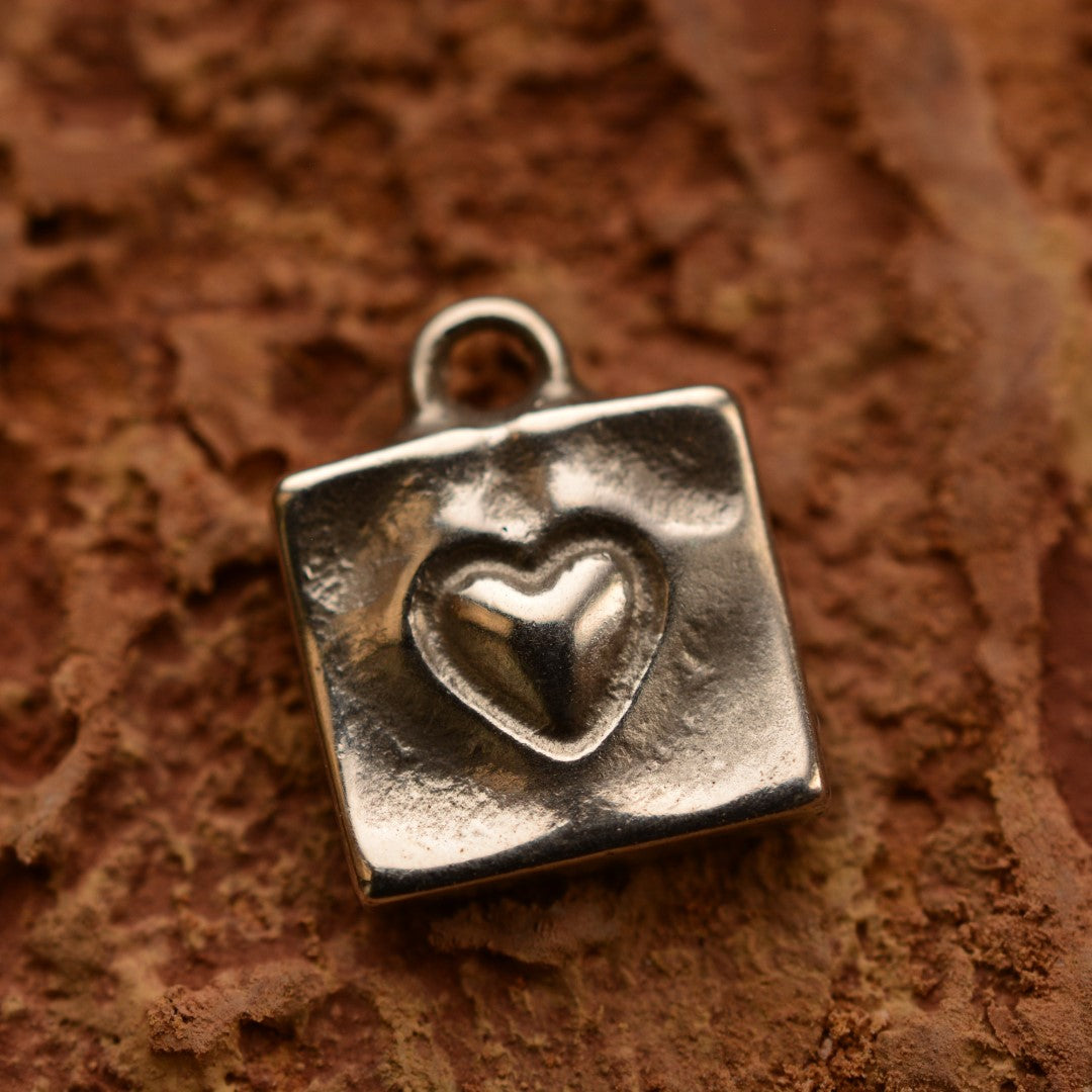 Сребърен медальон 925 „Сърце в квадрат“ – ръчно изработен талисман за любов и обич, бохо-рустик скулптурно бижу от Арт Дива, заснето върху каменен фон.