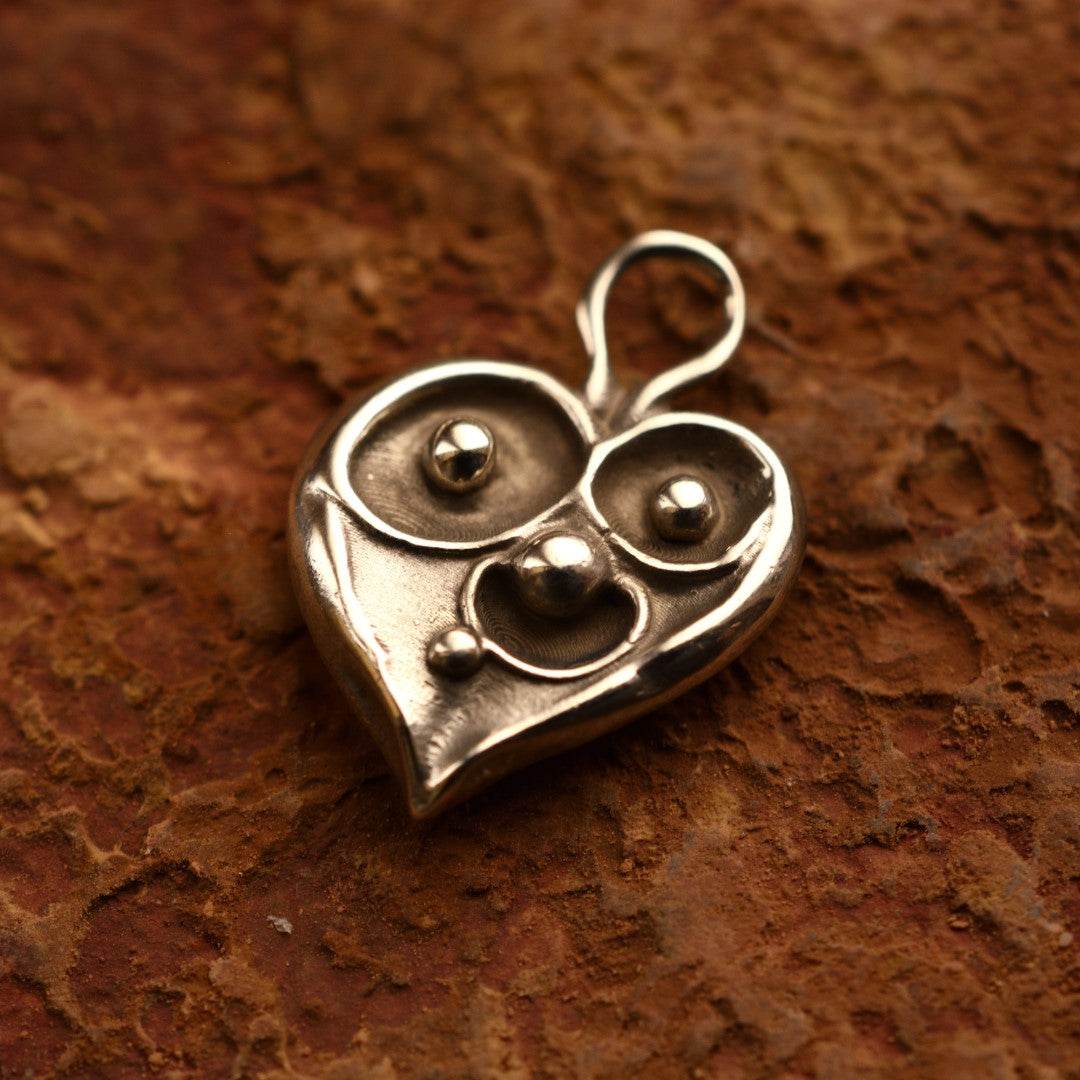 Сребърен медальон 925 „Семейно сърце“ – ръчно изработен талисман за любов, обич и семейна връзка, бохо-рустик скулптурно бижу от Арт Дива, заснето върху естествен глинен фон.
