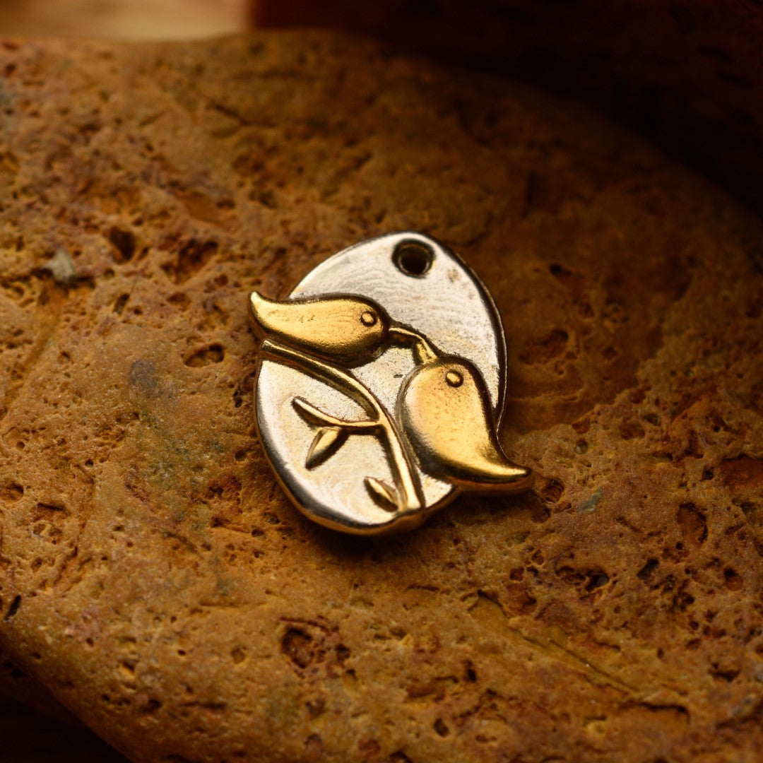 Ръчно изработен сребърен медальон 925 „Влюбени пиленца“ със златни акценти – талисман на любовта, хармонията и споделеното щастие, бохо-рустик скулптурно бижу от Арт Дива, заснето върху топъл каменен фон.
