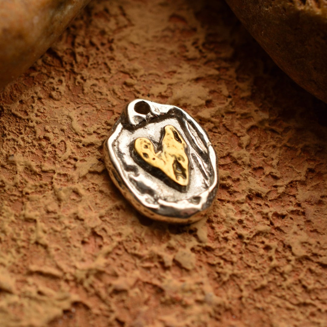 Сребърен медальон 925 „Златно сърце“ – ръчно изработено бохо-рустик скулптурно бижу, символ на любов и топлина, сребро със златни акценти от Арт Дива, заснето върху каменен фон.
