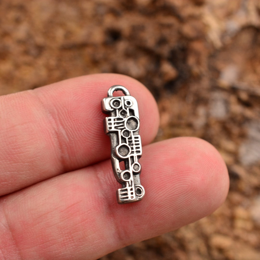 Сребърна висулка 925 „Пулс“ – ръчно изработено скулптурно бижу, символ на сила и ритъм, артистичен бохо-рустик дизайн от ArtDiva, заснето върху глинен фон.